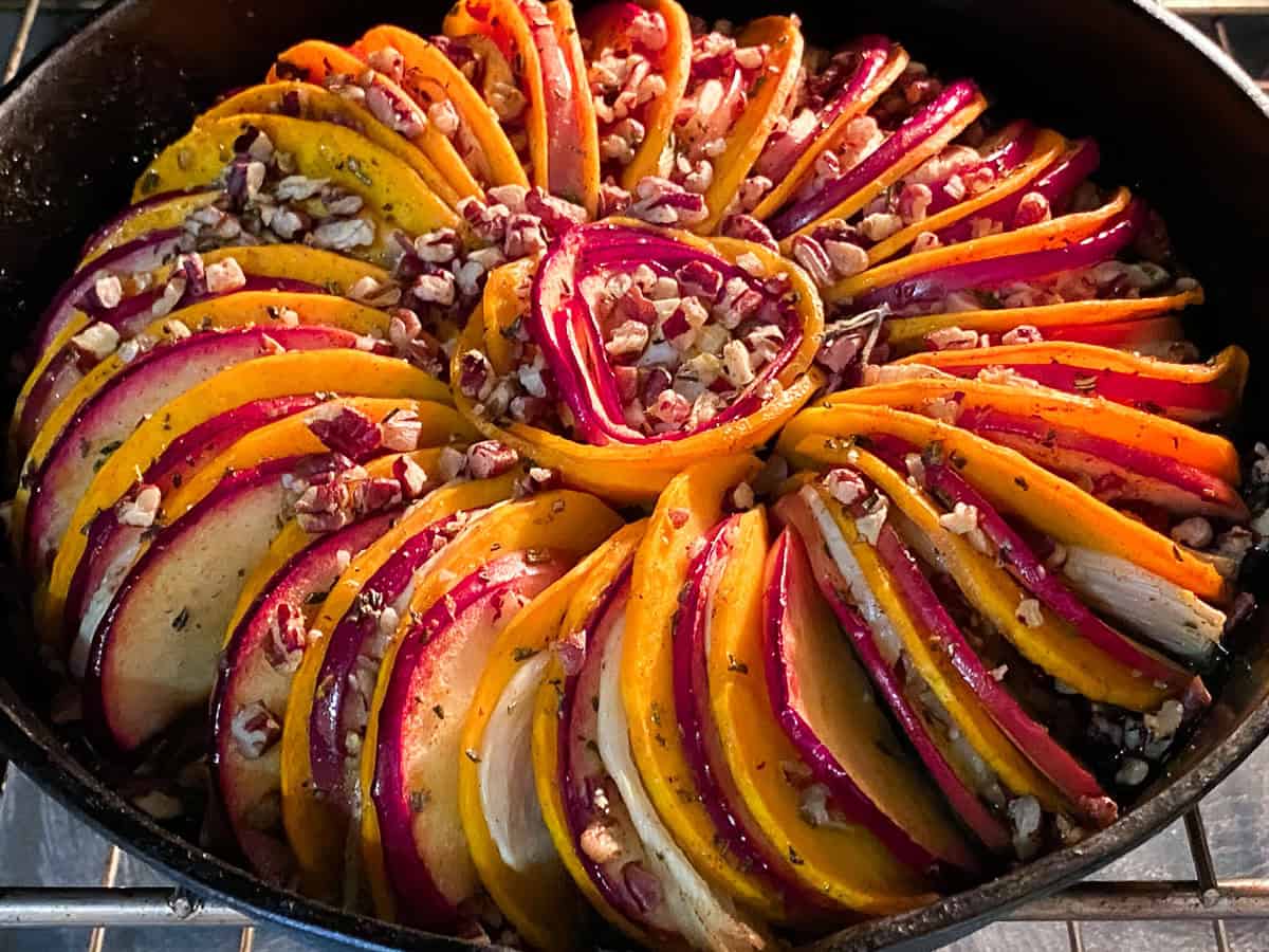 Butternut squash tian in the oven with nuts on the top.