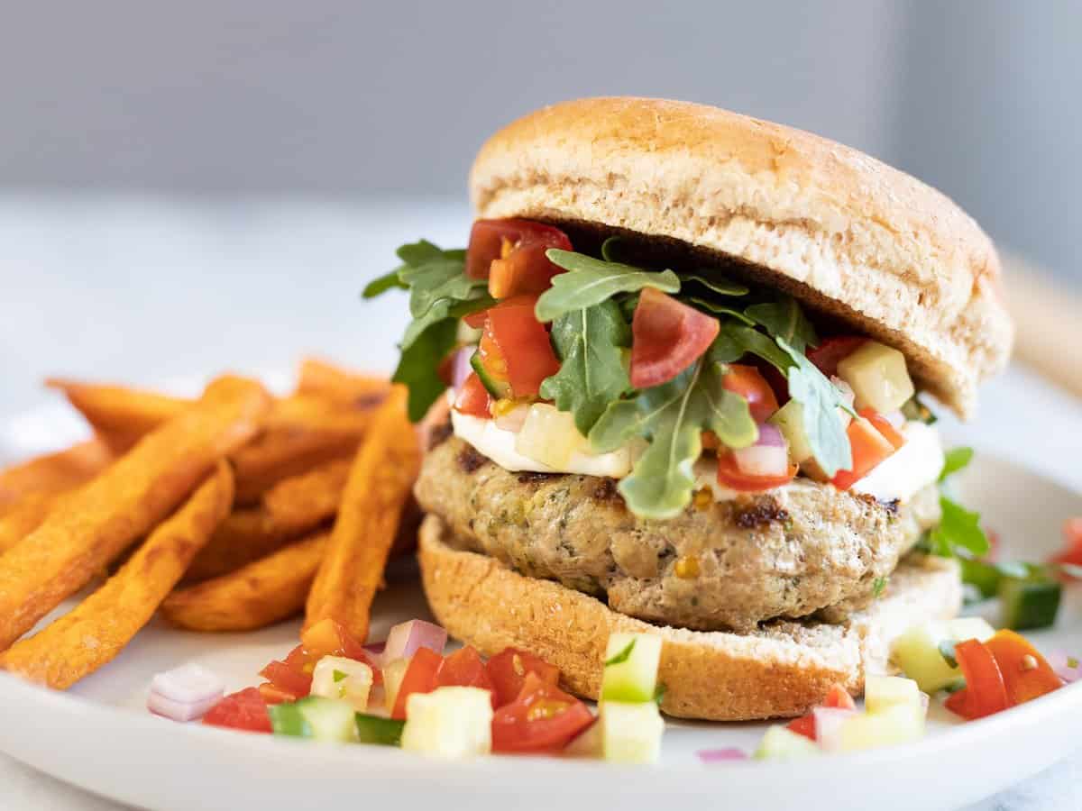 Greek turkey burger on a bun spread with whipped feta and Greek salsa