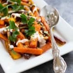 spice roasted carrots on a plate with a spoon