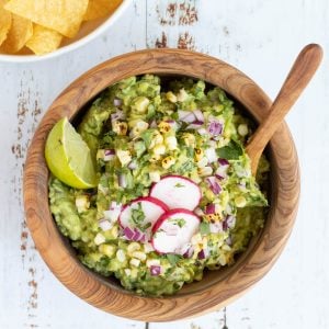picture of guacamole in a bowl next to a bowl of tortilla chips