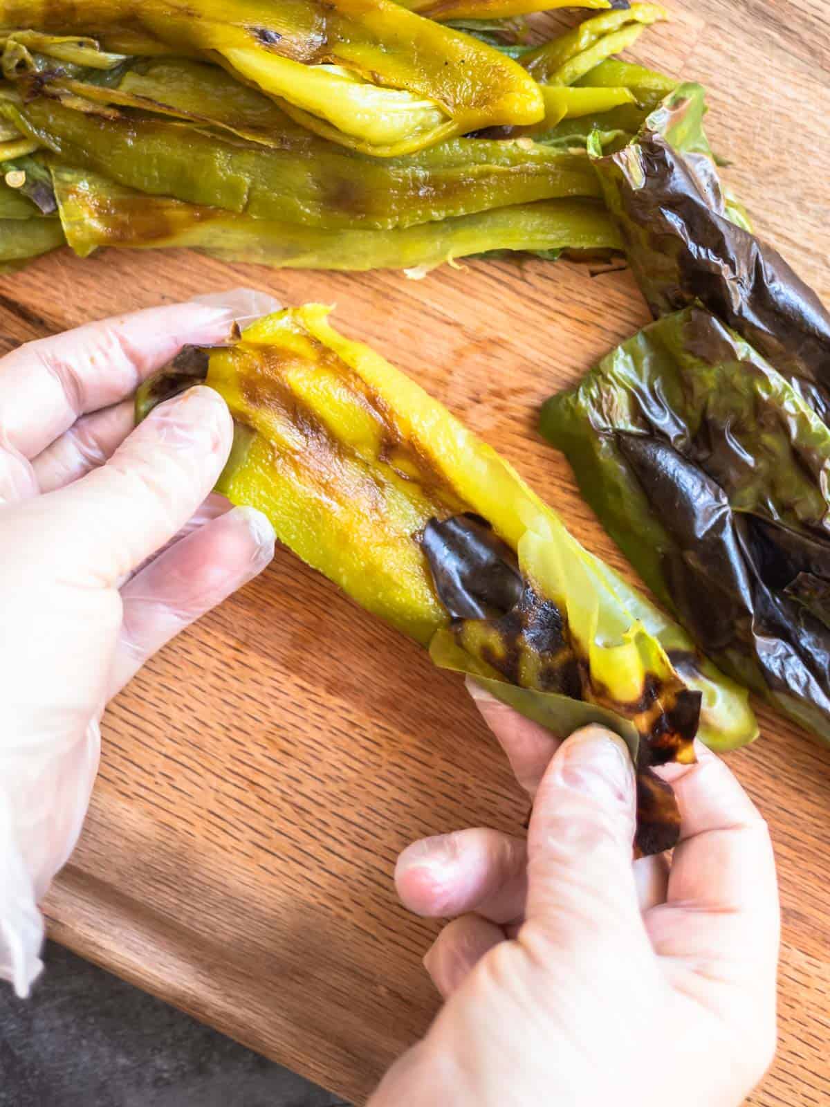 Photo of the skin being pulled off a roasted Hatch chile