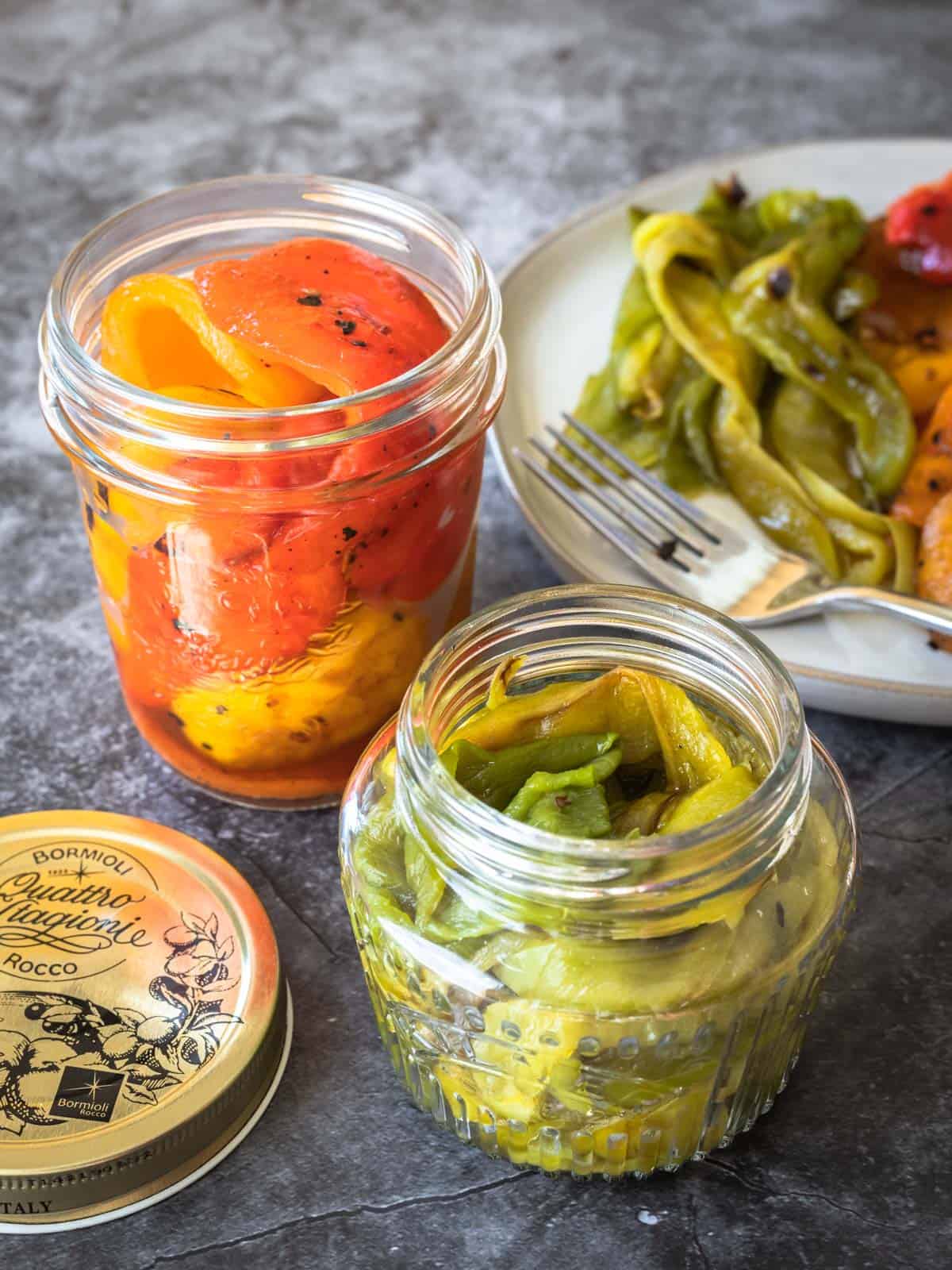 Photo of roasted peppers packed into glass jars for storage.