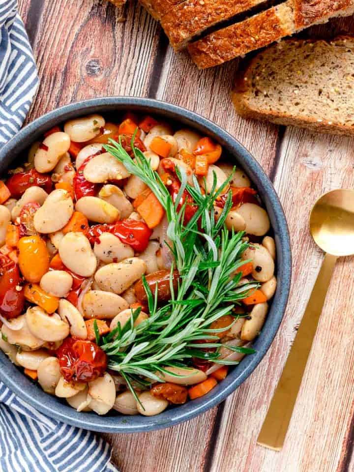 Italian butter beans in a bowl with a spoon and bread