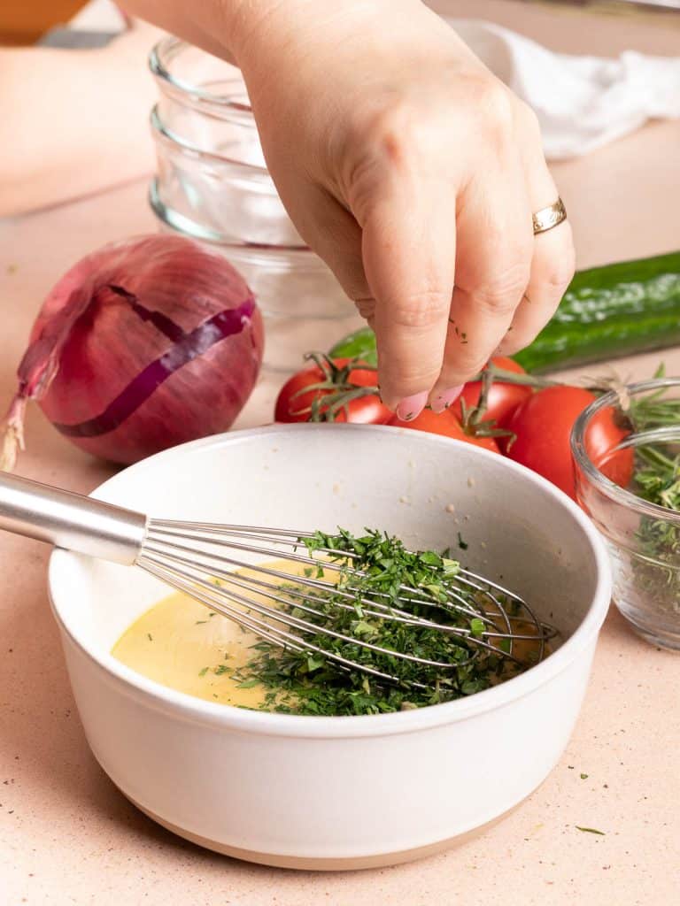 Adding herbs to Mediterranean Herb Vinaigrette.