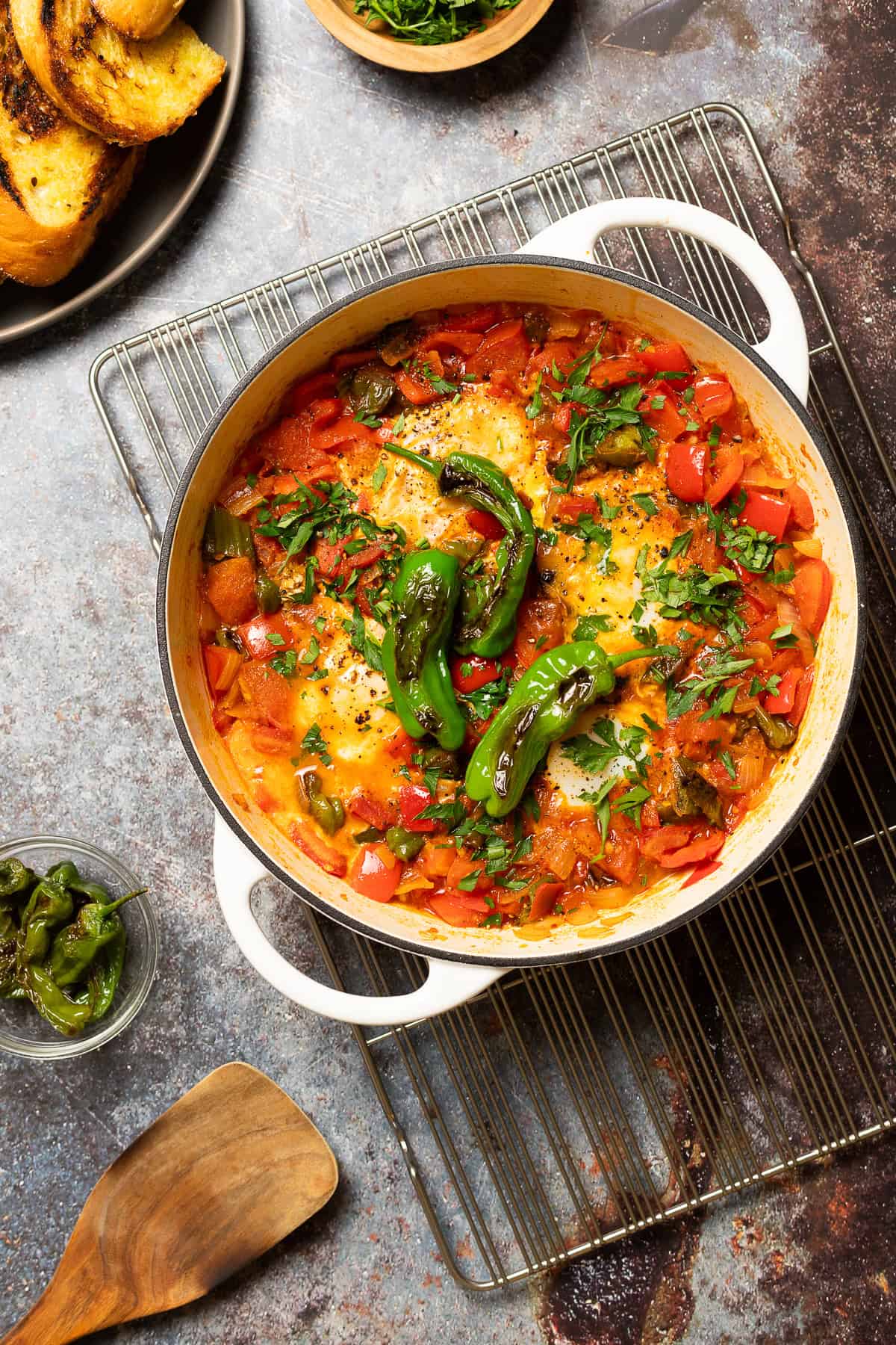 a pot of shakshuka sitting on a cooling rack.