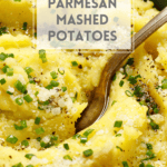 Pinterest Pin for Parmesan Mashed Potatoes with Olive Oil. Shows fluffy mashed potatoes in a bowl with a serving spoon. Garnished with grated parmesan cheese, black pepper, chives, and a drizzle of olive oil.