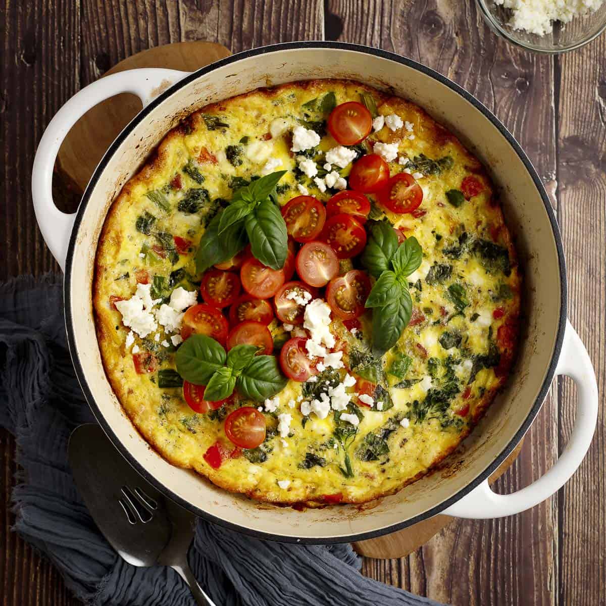 Broccolini frittata with turkey bacon and feta in a pan.