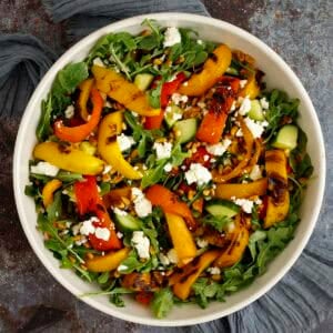 grilled pepper salad with arugula and feta in a bowl