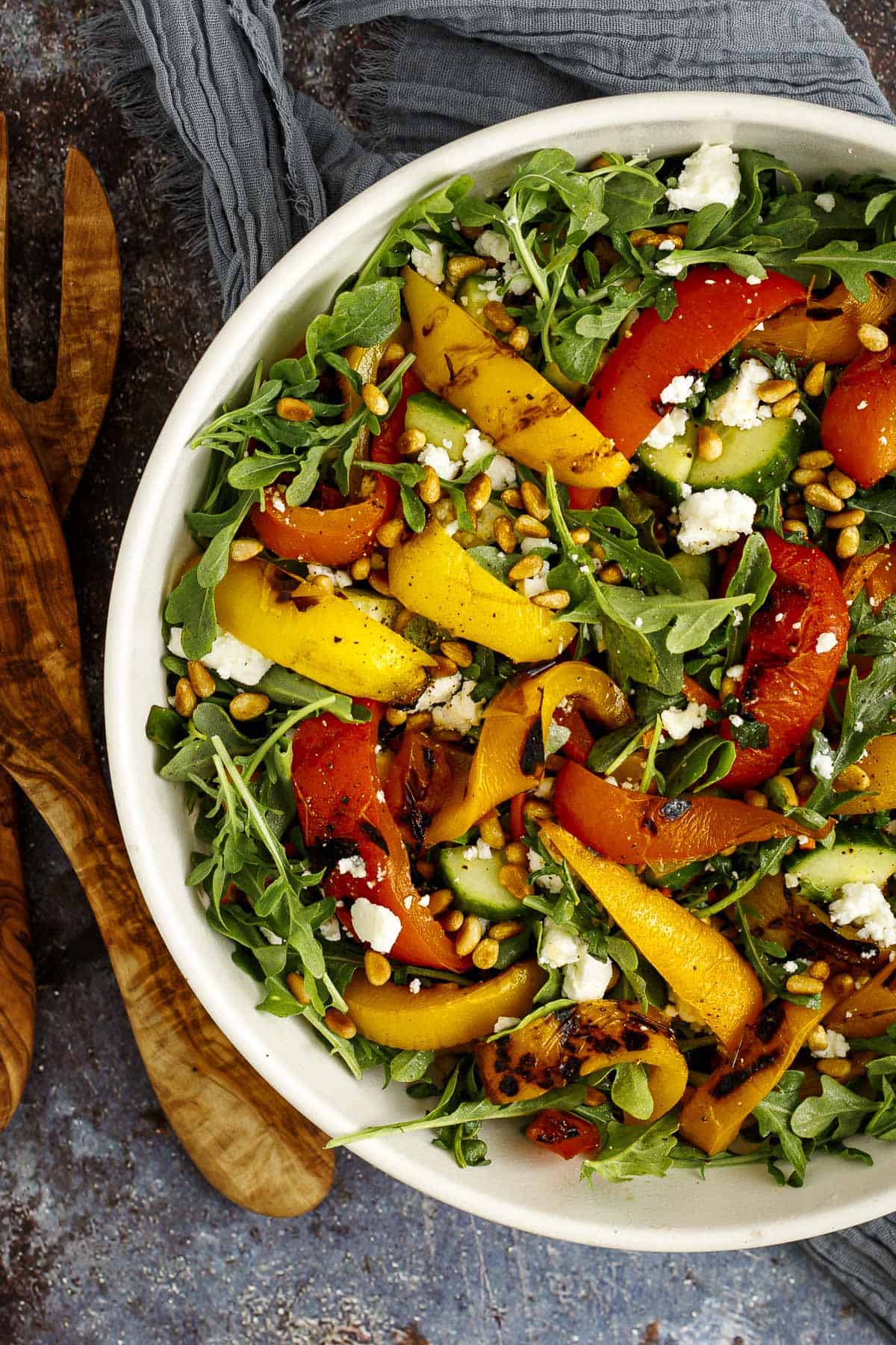 grilled pepper salad in a bowl with salad tongs