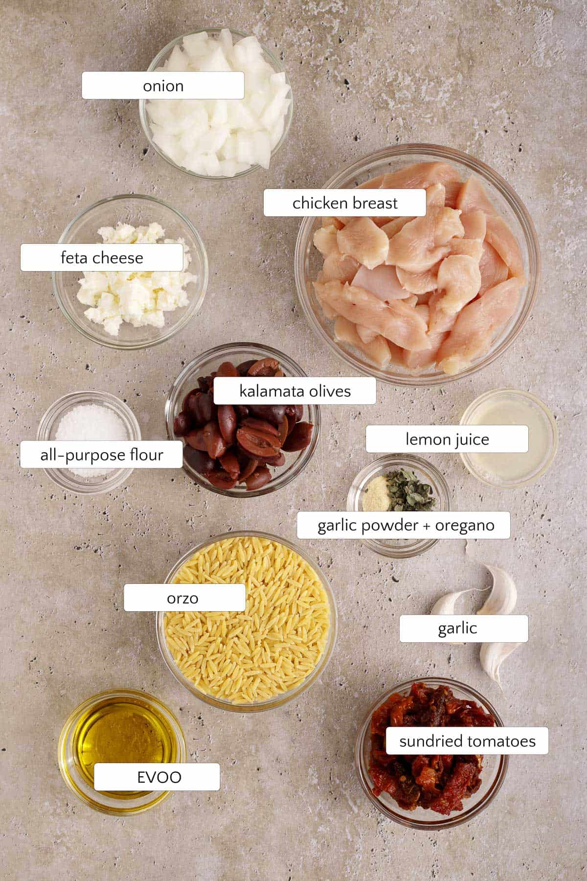ingredients for Mediterranean chicken orzo skillet include chicken breast, onion, feta cheese, sundried tomatoes, kalamata olives, salt, garlic powder, oregano, lemon juice, and olive oil.