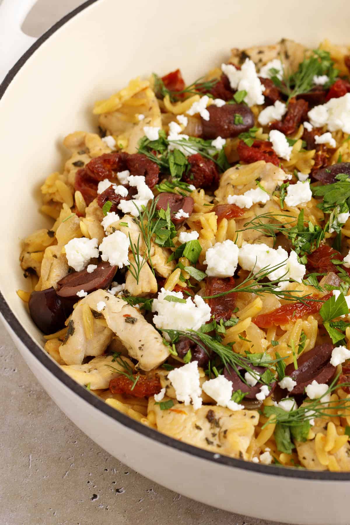 Mediterranean chicken orzo skillet in a pan.
