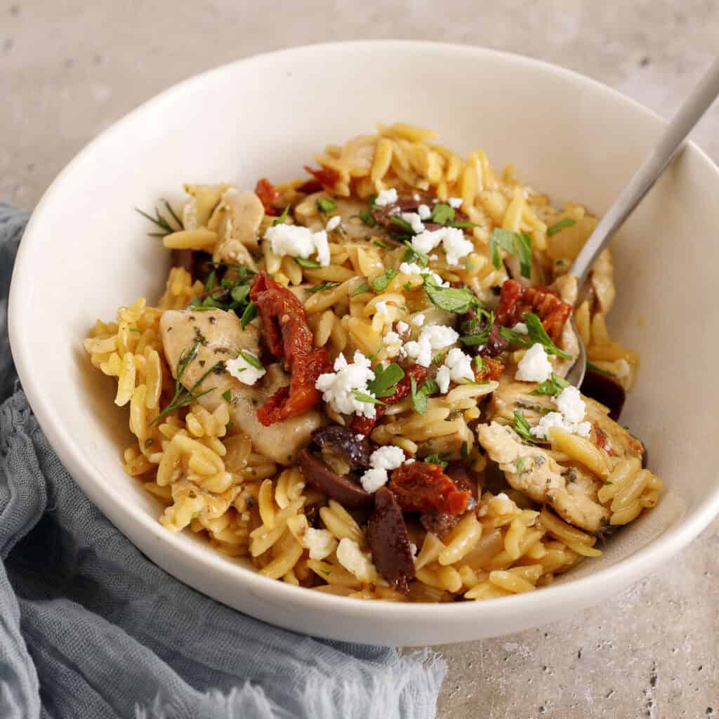 chicken orzo skillet dinner in a bowl with a spoon
