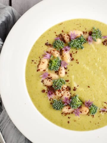 broccolini soup in a bowl with a spoon and a napkin.