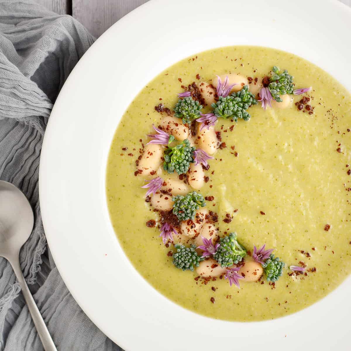 broccolini soup in a bowl with a spoon and a napkin.