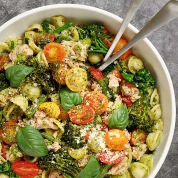 Broccolini pasta with pesto and tuna in a bowl with serving utensils