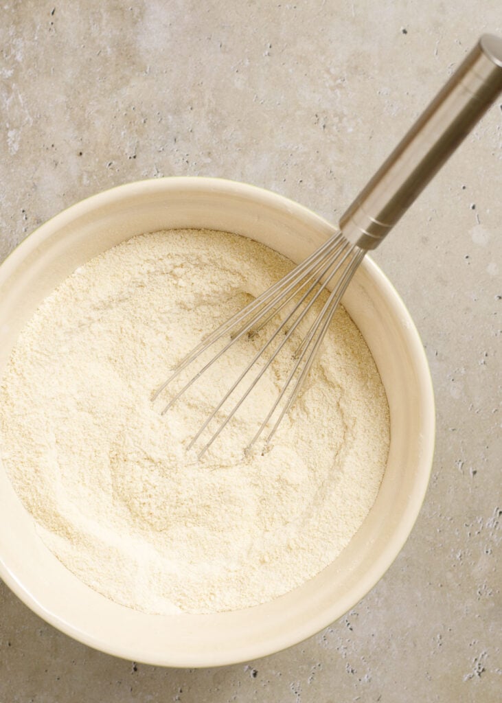 Flour in a mixing bowl with a whisk for cooking or baking at Parsley & Parm.