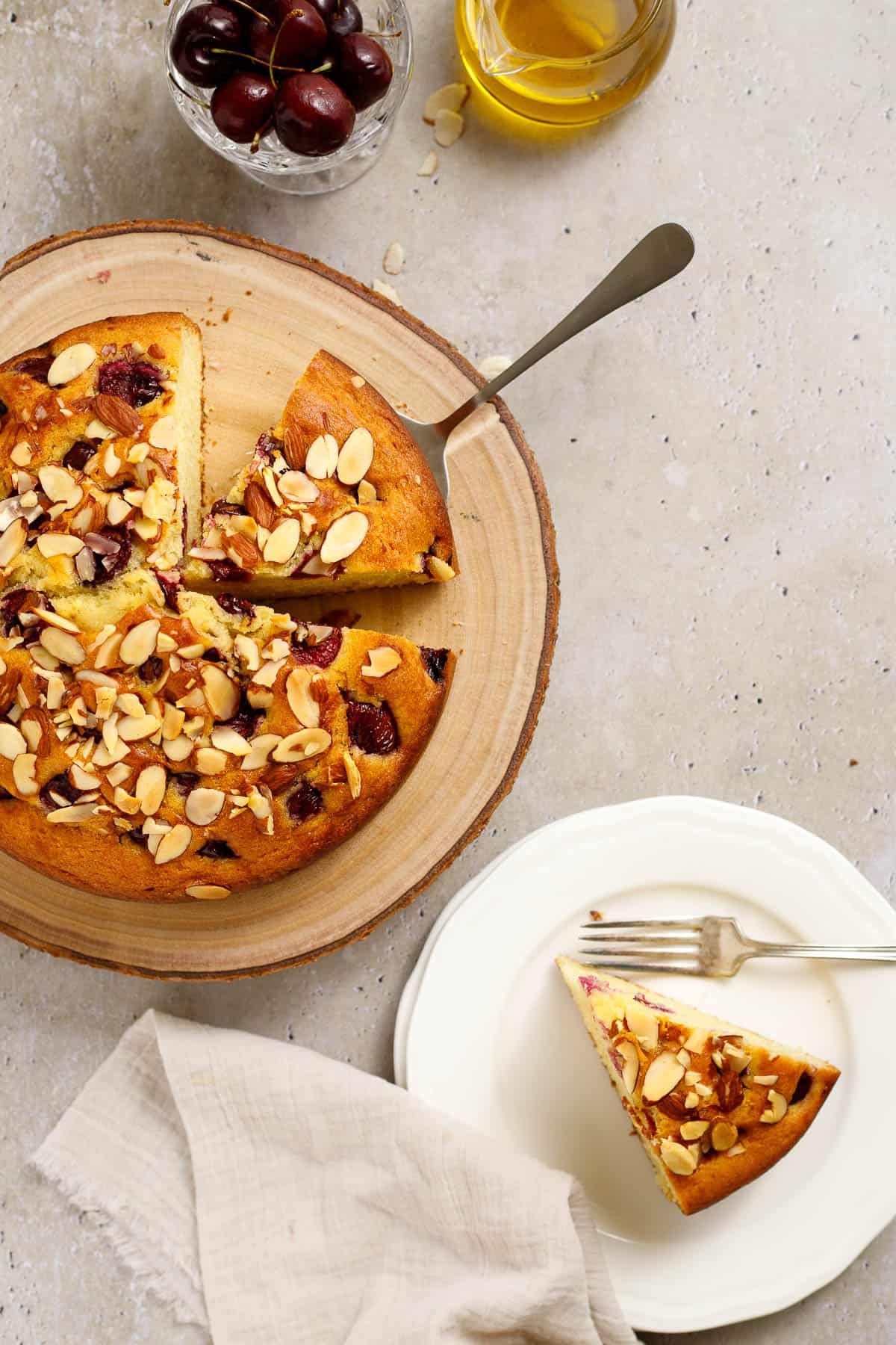 Cherry almond olive oil cake topped with sliced almonds.