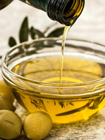 olive oil being drizzled in a bowl. Photo by Pexels.