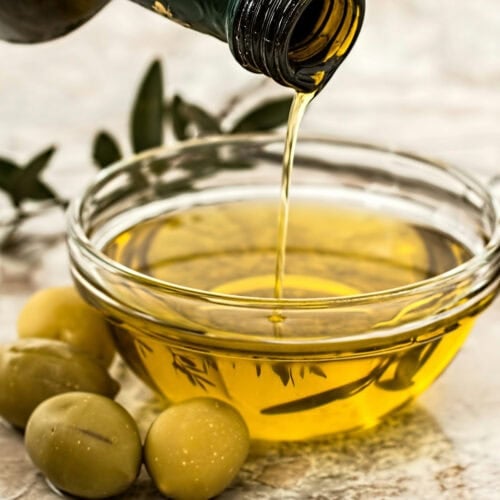 olive oil being drizzled in a bowl. Photo by Pexels.