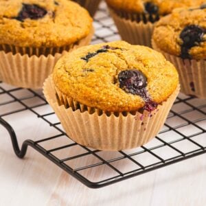 whole grain banana blueberry muffins on a wire cooling rack.