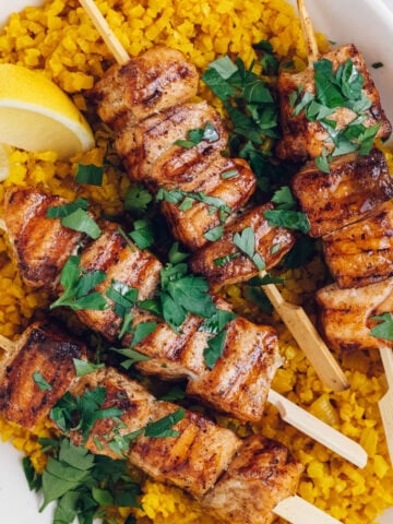cubes of salmon threaded on to skewers and grilled, served with yellow cauliflower rice.